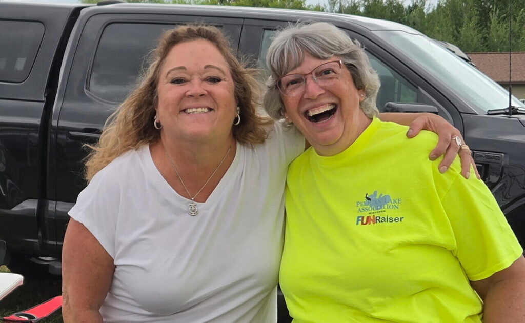Two women smiling at an association event
