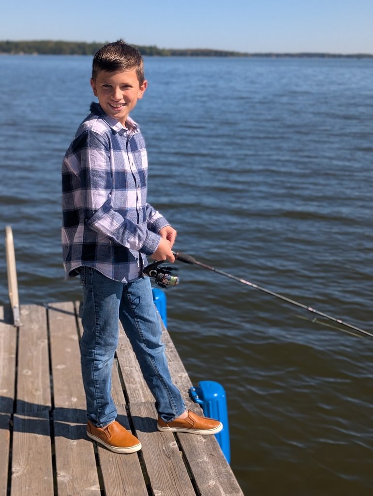 Boy fishing from a dock on Pelican Lake