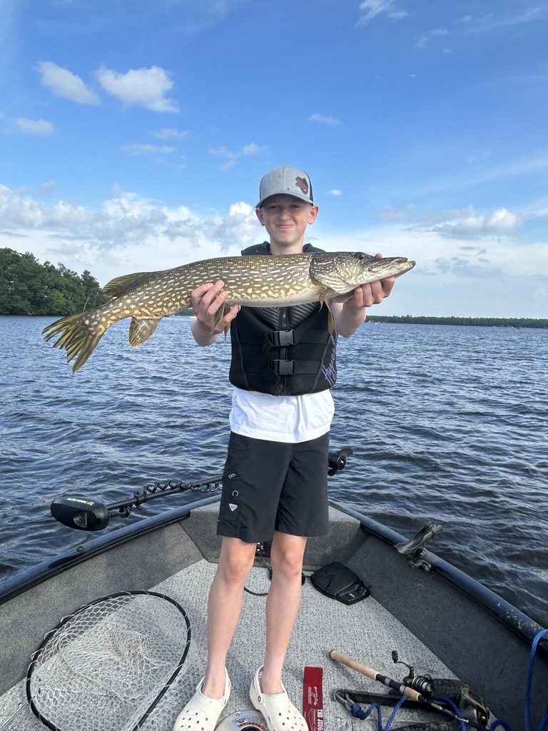 Young angler holding a northern pike