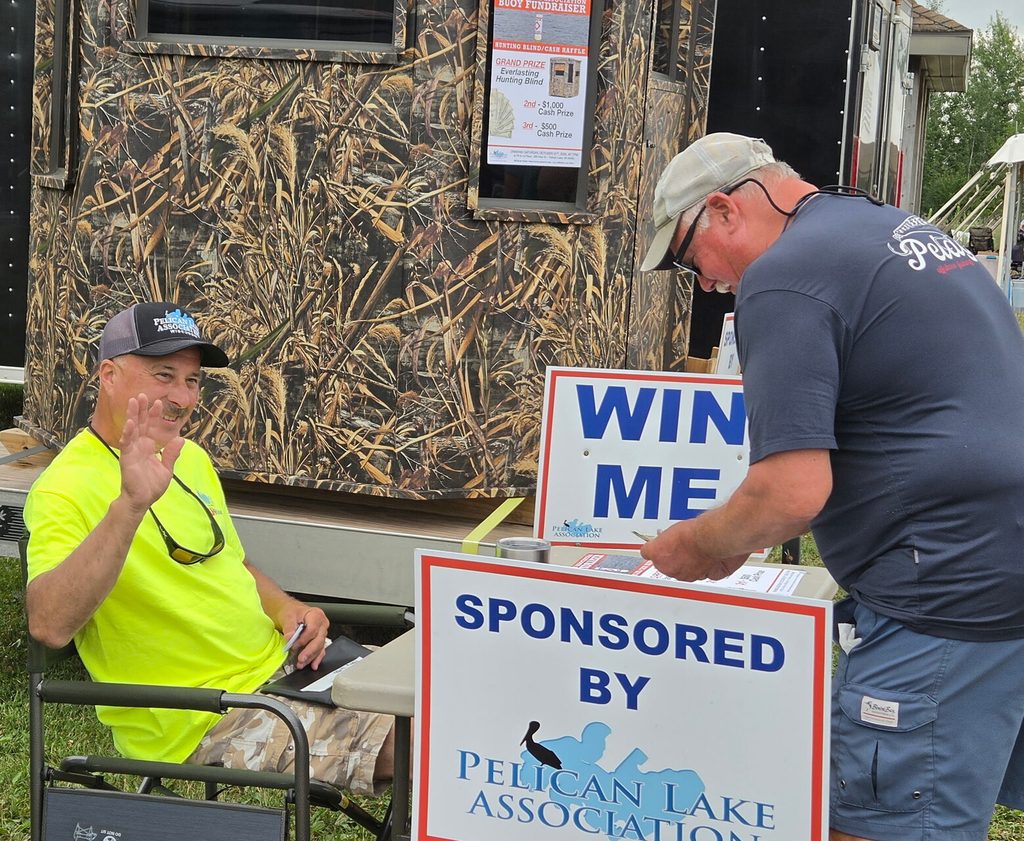 Volunteer at a raffle booth with a hunting blind prize