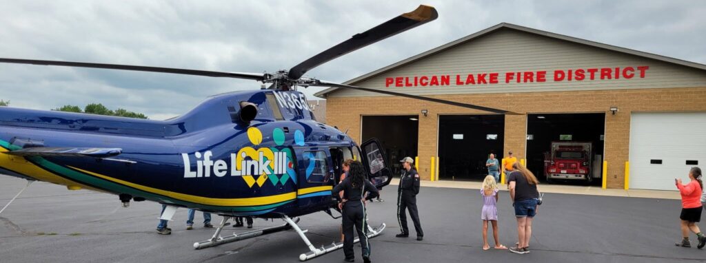 Pelican Lake Fire District Building with Lifelink 3 helicopter outside of the bay doors during a PLA event.